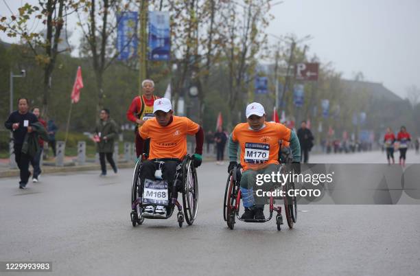 Wheelchair-bound runners take part in the "over 100 Km Marathon around Leigong Mountain" race at Danzhai Station in Qiandongnan, Southwest China's...