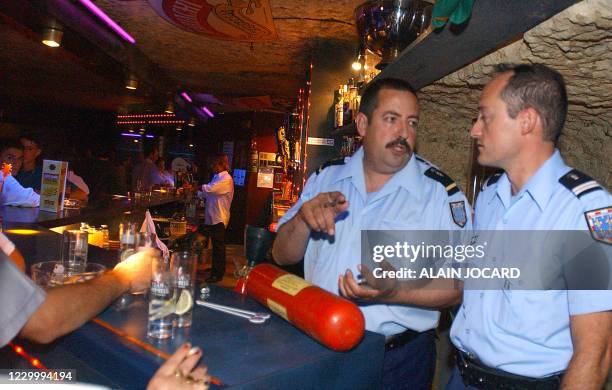 Deux gendarmes du peloton de gendarmerie de Bléré vérifient, le 12 Juillet 2002 dans une discothèque du village de Civray, près de Tours, la...