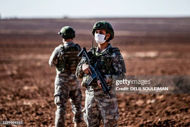 Turkish soldiers stand guard during a joint Russian-Turkish patrol in the eastern countryside of the town of Darbasiyah near the border with Turkey...