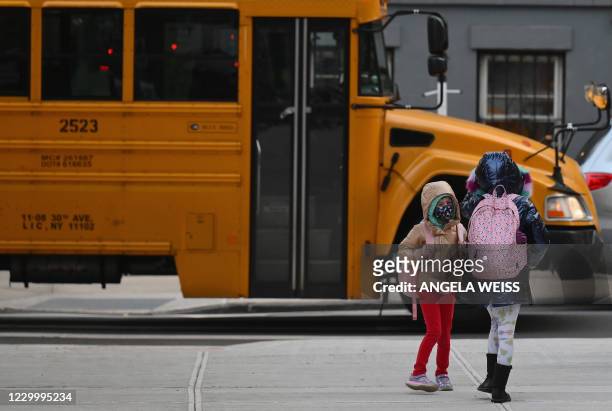 Children arrive for class on the first day of school reopening on December 7, 2020 in the Brooklyn borough of New York City. - The novel coronavirus...