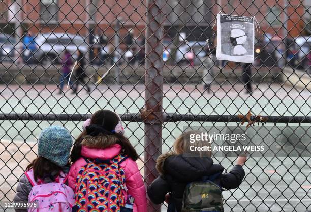 Children look at their school ground as they wait for class on the first day of school reopening on December 7, 2020 in the Brooklyn borough of New...