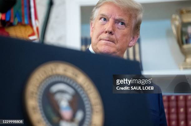 President Donald Trump looks on during a ceremony presenting the Presidential Medal of Freedom to wrestler Dan Gable in the Oval Office of the White...