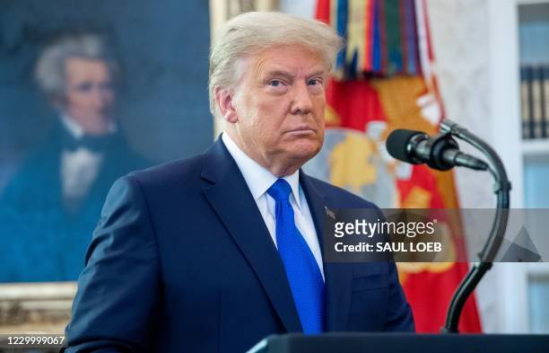 President Donald Trump looks on during a ceremony presenting the Presidential Medal of Freedom to wrestler Dan Gable in the Oval Office of the White...
