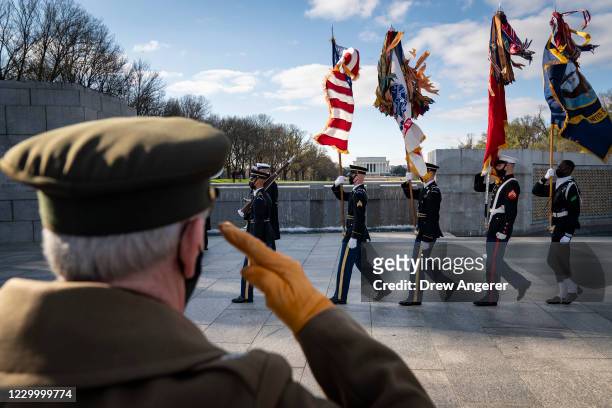 National Park Service Living History volunteer Patrick McCourt salutes as a military honor guard departs the World War II Memorial after a wreath...