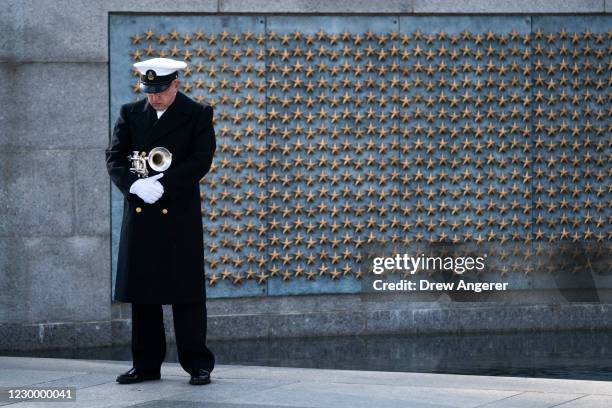 Trumpeter with a military honor guard pauses at the World War II Memorial during a wreath-laying ceremony to mark National Pearl Harbor Remembrance...