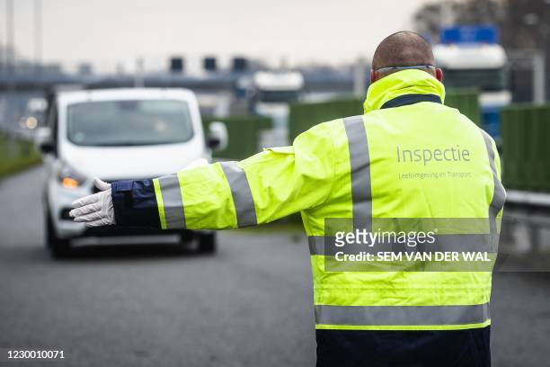 Employees of the Human Environment and Transport Inspectorate conduct a road check along the A12 near Babberich in the municipality of Zevenaar, on...
