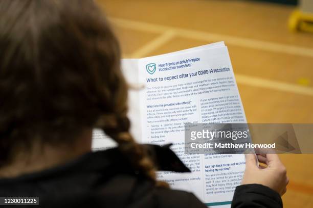 Woman reads a leaflet on the COVID-19 vaccine at Cardiff and Vale Therapy Centre on December 8, 2020 in Cardiff, Wales. More than 50 hospitals across...