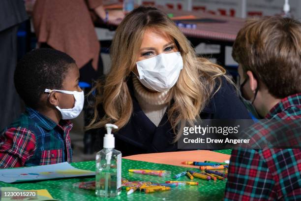 First Lady Melania Trump talks with children as they make Christmas cards during the annual Marine Toys for Tots Drive at Joint Base...