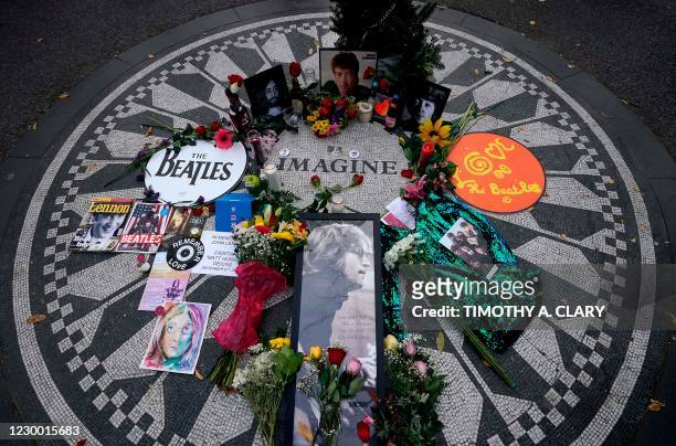 Picturs are seen on a monument as mourners gather on the 40th anniversary of John Lennon's death, at Strawberry Fields, in Central Park to honor the...