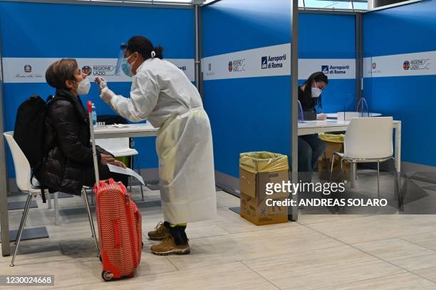Passenger who just landed from New York on an Alitalia flight undergoes a rapid antigen swab test for COVID-19 on December 9, 2020 at a testing...