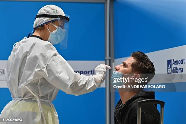 Passenger who just landed from New York on an Alitalia flight undergoes a rapid antigen swab test for COVID-19 on December 9, 2020 at a testing...