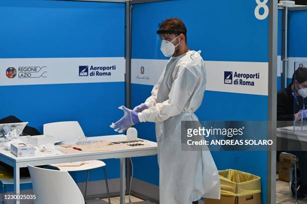 Lab personnel prepares to perform rapid antigen swab tests for COVID-19 on passengers who just landed from New York on an Alitalia flight, on...