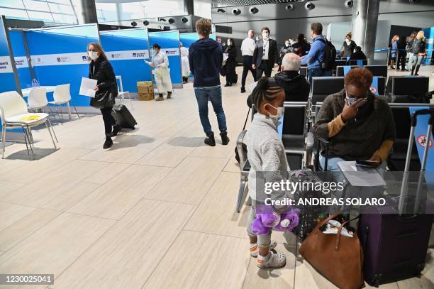 Passengers who just landed from New York on an Alitalia flight wait to go through booths to undergo a rapid antigen swab test for COVID-19 on...