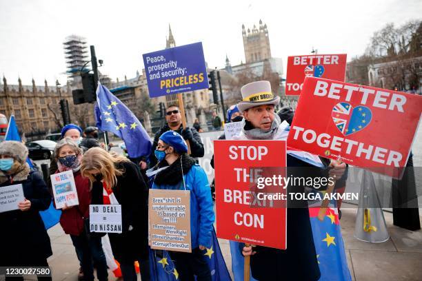 Pro-EU anti-Brexit protesters hold placards outside the Houses of Parliament in London on December 9, 2020. - British Prime Minister Boris Johnson...