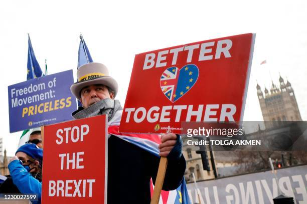Pro-EU anti-Brexit protesters hold placards outside the Houses of Parliament in London on December 9, 2020. - British Prime Minister Boris Johnson...