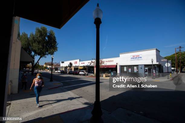 Pedestrians walks past a closed business along Main Street where many businesses struggle to stay open and many have closed during California...