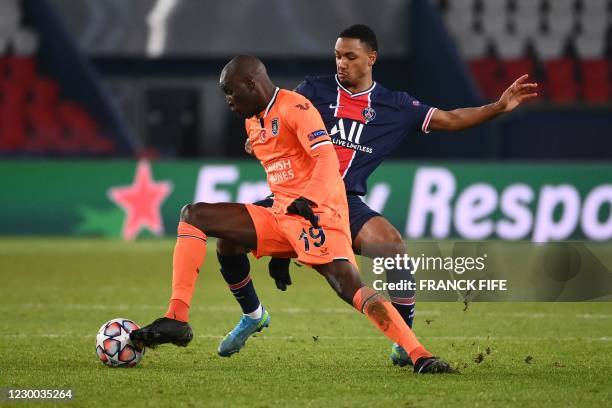 Istanbul Basaksehir's French forward Demba Ba is challenged by Paris Saint-Germain's Portuguese midfielder Danilo Pereira during the UEFA Champions...