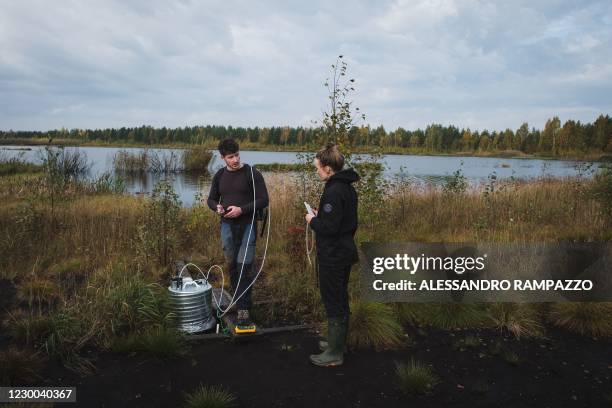 Ecologist Antoine Scherer and junior specialist Noora Huusari measure the Methane gas emissions of the Linnunsuo reserve, a former peat farm taken...