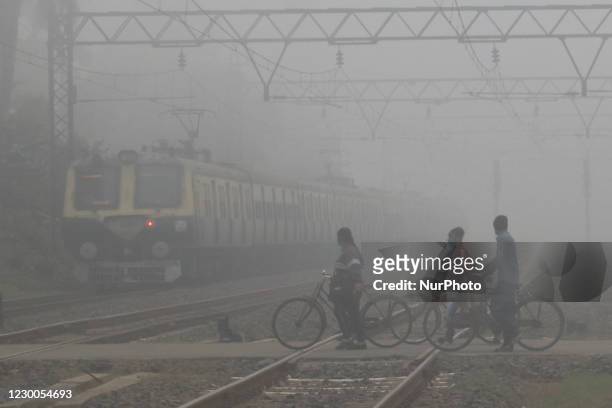 People move past railway tracks surrounded by fog early morning in Near Kolkata city ,India , Thursday on December 10,2020. Large parts of north...