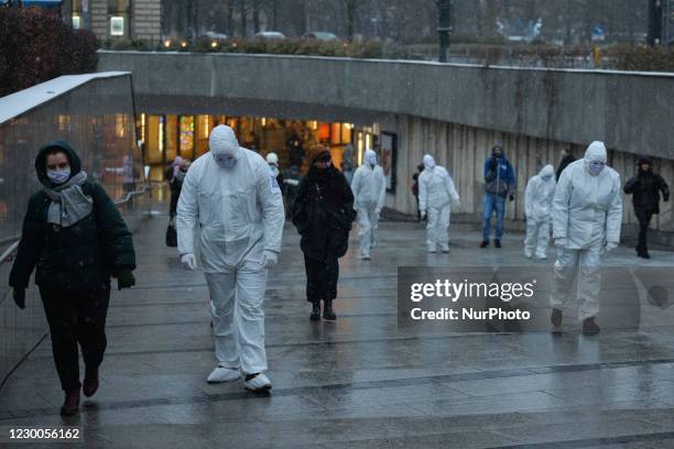 Group of activists wearing the personal protective equipment suits, during an anti-vaccine, anti-restrictions and against social conformity, march...