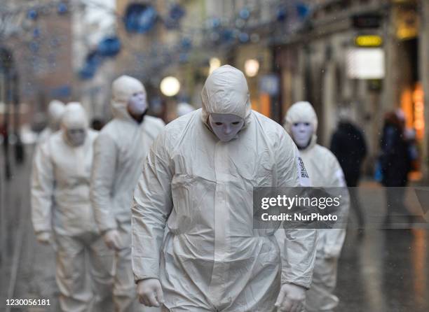 Group of activists wearing the personal protective equipment suits, during an anti-vaccine, anti-restrictions and against social conformity, march...