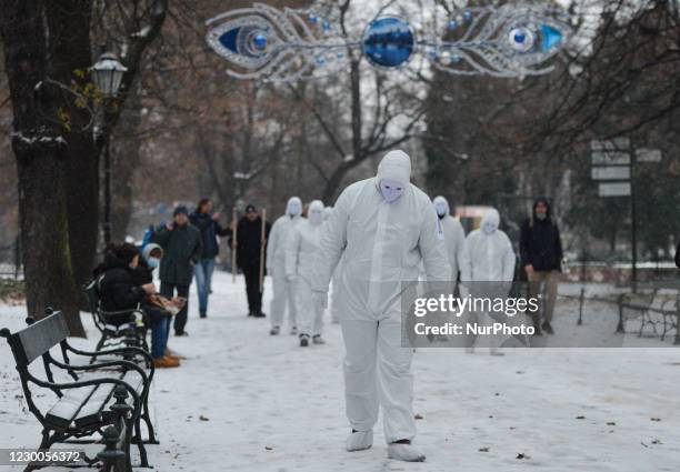 Group of activists wearing the personal protective equipment suits, during an anti-vaccine, anti-restrictions and against social conformity, march...