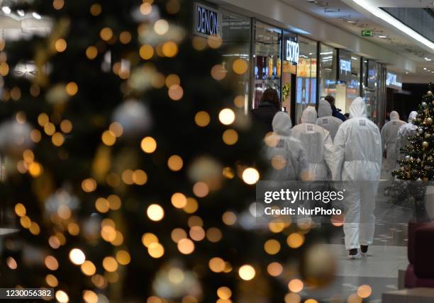 Group of activists wearing the personal protective equipment suits, during an anti-vaccine, anti-restrictions and against social conformity, march...