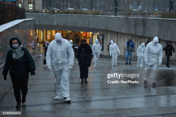 Group of activists wearing the personal protective equipment suits, during an anti-vaccine, anti-restrictions and against social conformity, march...