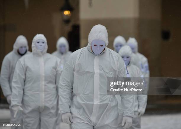 Group of activists wearing the personal protective equipment suits, during an anti-vaccine, anti-restrictions and against social conformity, march...