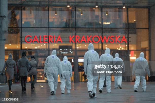 Group of activists wearing the personal protective equipment suits, during an anti-vaccine, anti-restrictions and against social conformity, march...