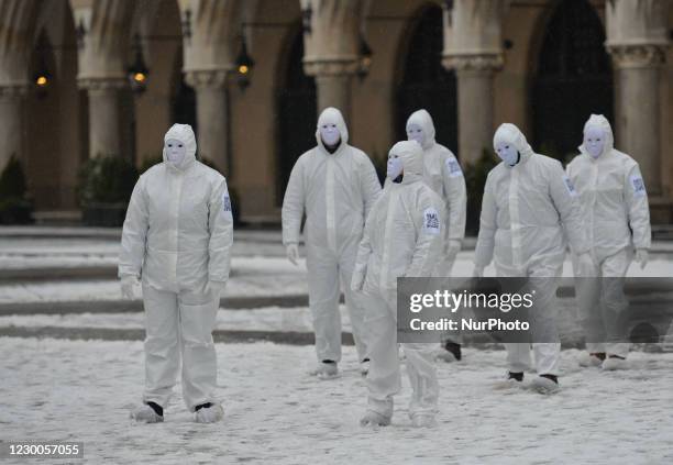 Group of activists wearing the personal protective equipment suits, during an anti-vaccine, anti-restrictions and against social conformity, march...