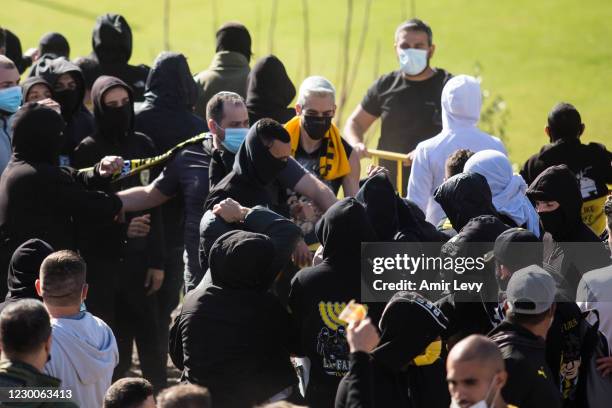 Fans of Beitar Jerusalem Football Club 'La Familia' clash with other team fans during a training session on December 11, 2020 in Jerusalem, Israel....