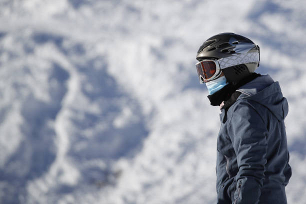 Snowboarder wears a protective face mask on a run at the Kleine Scheidegg ski resort in Grindelwald, Switzerland, on Thursday, Dec. 10, 2020. The...