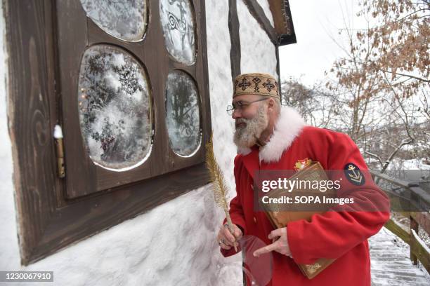 An actor dressed like St. Nicholas looks into the window of a house. The tradition of Saint Nicholas Day is a festival for children in most Orthodox...