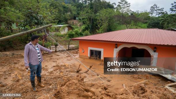Carlos Vasquez looks at damaged homes after the passage of Hurricanes Eta and Iota in Proteccion, Santa Barbara department, Honduras, on December 11,...