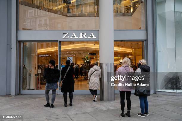 People wait outside a Zara store on Oxford Street on December 12, 2020 in London, England.