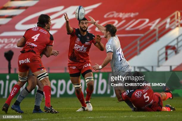 Sale Sharks's Irish fly half Alan McGinty is tackled by Toulon's Samoa lock Brian Aliinuuese and Toulon's French flanker Raphael Lakafia during the...