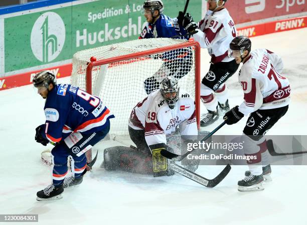 Brody Sutter of Iserlohn Roosters and goalkeeper Justin Pogge of Koelner Haie battle for the puck during the Ice Hockey Test Match between Iserlohn...