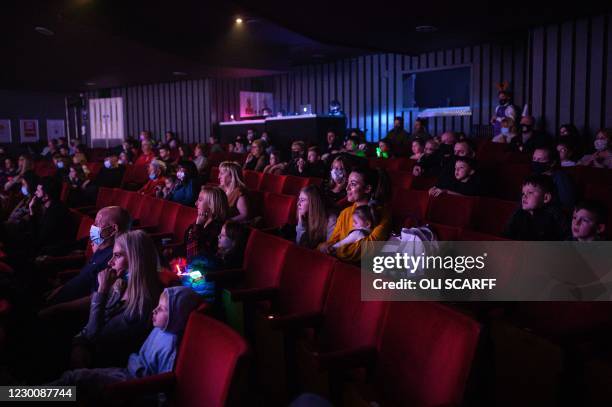 Audience members, sat in socially-distanced groups, watch the Christmas pantomime 'Beauty and the Beast' at St Helens Theatre Royal, in St Helens,...