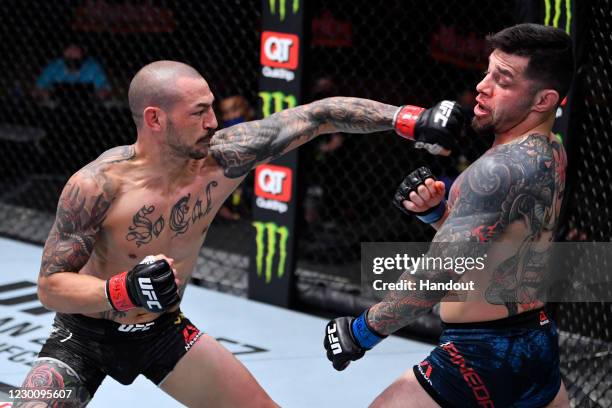 In this handout image provided by UFC, Cub Swanson punches Daniel Pineda in their featherweight bout during the UFC 256 event at UFC APEX on December...