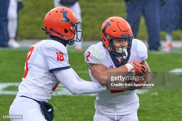 Illinois Fighting Illini quarterback Matt Robinson hands the football to Illinois Fighting Illini running back Chase Brown in action during a game...