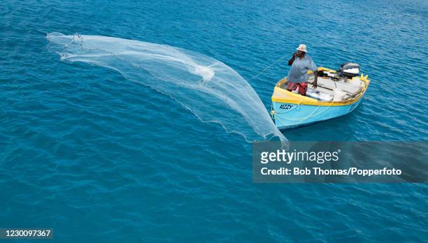 Local fisherman Melbourne Richards casting his fishing net in the Caribbean Sea near Bridgetown, on the West coast of Barbados, 19th November 2018.