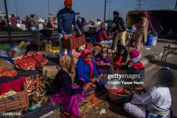 Indian women volunteers make food for farmers protesting against the new farm laws on December 13, 2020 at the Delhi-Uttar Pradesh border in...