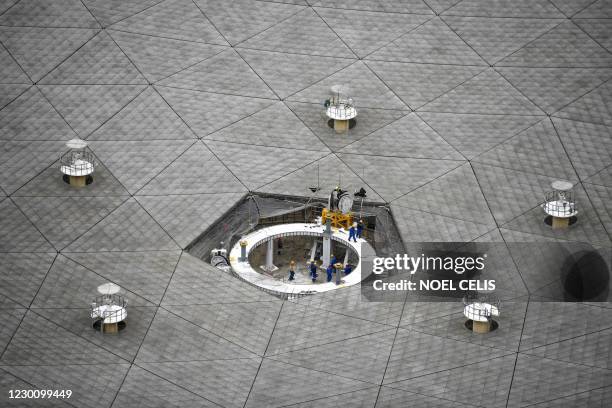 Workers are seen at the Five-hundred-meter Aperture Spherical radio Telescope during maintenance work at the National Astronomical Observatories,...