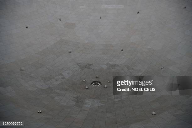 Workers are seen at the Five-hundred-meter Aperture Spherical radio Telescope during maintenance work at the National Astronomical Observatories,...