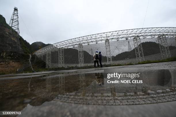 Employees are seen in front of the Five-hundred-meter Aperture Spherical radio Telescope at the National Astronomical Observatories, Chinese...