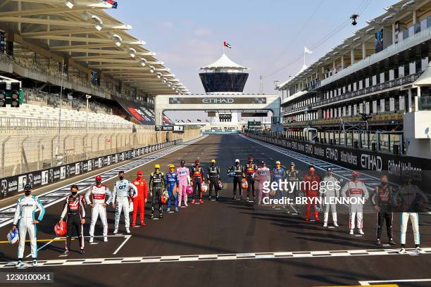 Drivers pose for the end of the year group photo on the starting grid ahead of the Abu Dhabi Formula One Grand Prix at the Yas Marina Circuit in the...