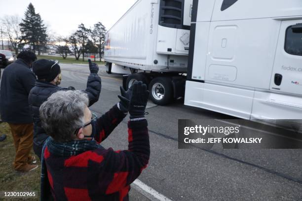 Nancy Galloway and Susan Deur cheer as trucks carrying the first shipment of the Covid-19 vaccine that is being escorted by the US Marshals Service,...