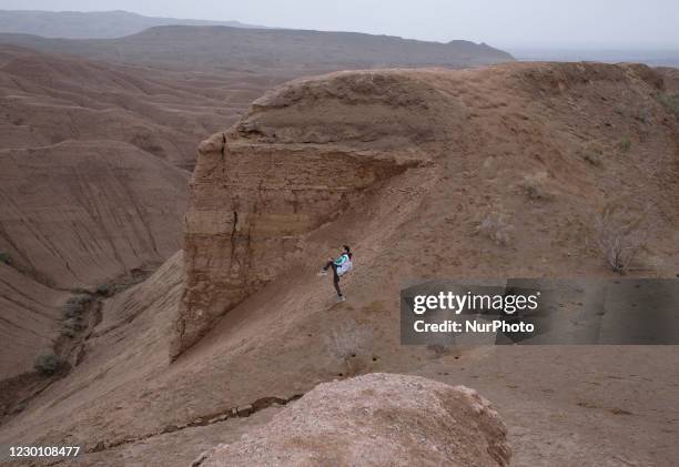 An Iranian man exercises while standing of a sandy hill in Khatabshekan desert in Aran-va-Bidgol county in Isfahan province about 320km south of...