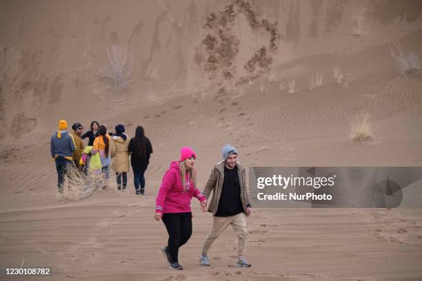 An Iranian man and his relative walk along an area in Khatabshekan desert in Aran-va-Bidgol county in Isfahan province about 320km south of Tehran...